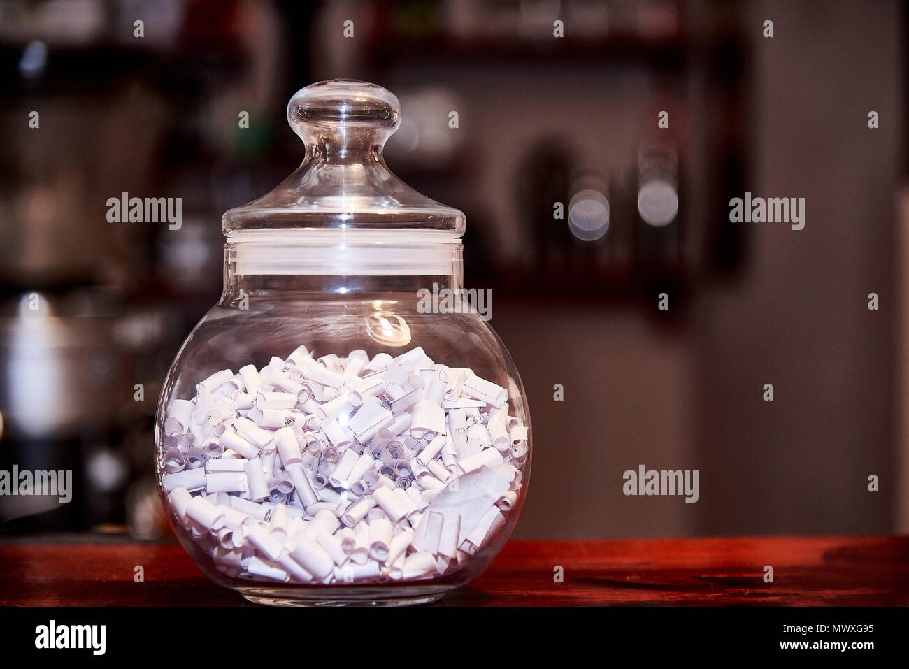Glass jar with predictions stands on a wooden table Stock Photo