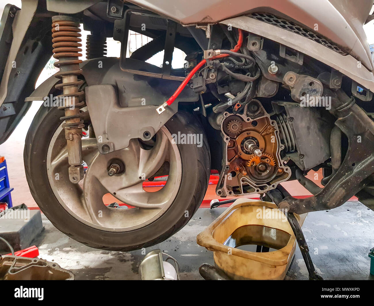 Maintenance motorbike repair automotive worker, oil engine change Stock