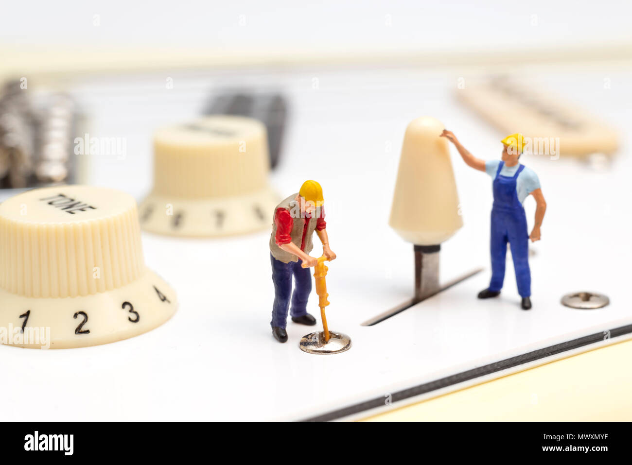Miniature Workers Fixing The Control Switch Of An Electric Guitar Stock Photo
