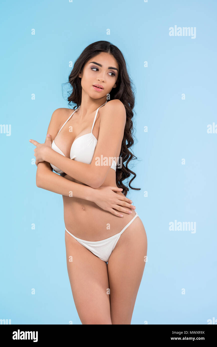 attractive slim girl in white bikini, isolated on blue Stock Photo - Alamy