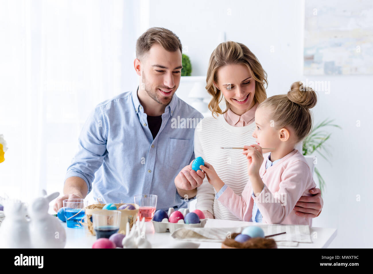 Parents and daughter painting Easter eggs Stock Photo