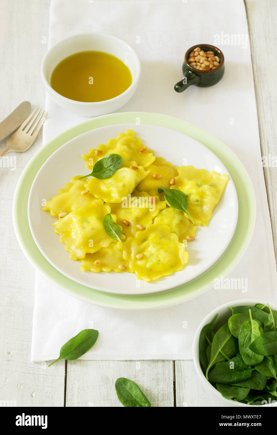 Ravioli with ricotta and spinach, served with olive oil and pine nuts