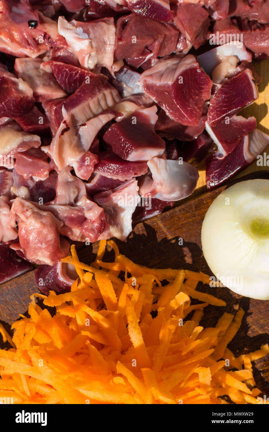 Isolated bird chicken giblets gizzards stomachs, hearts with vegetables