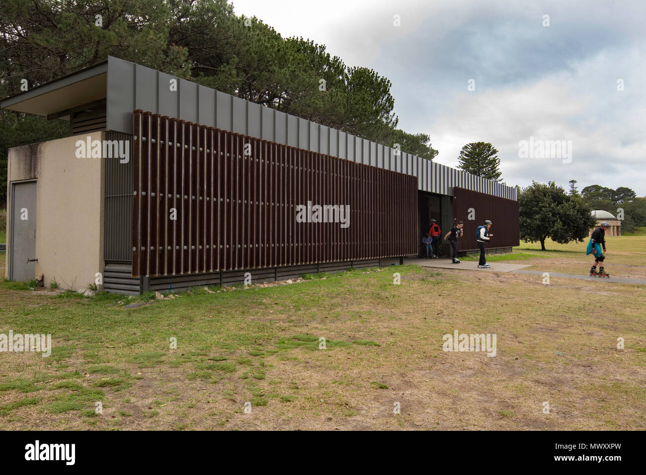 A rollerblading family leave the architect designed public conveniences (toilets) in Centennial Park Sydney, Australia Stock Photo