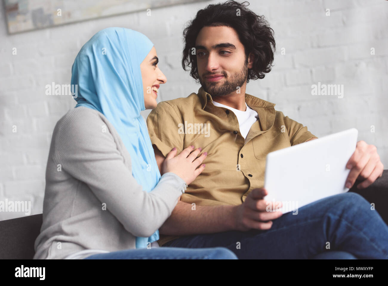 smiling muslim couple using tablet at home Stock Photo