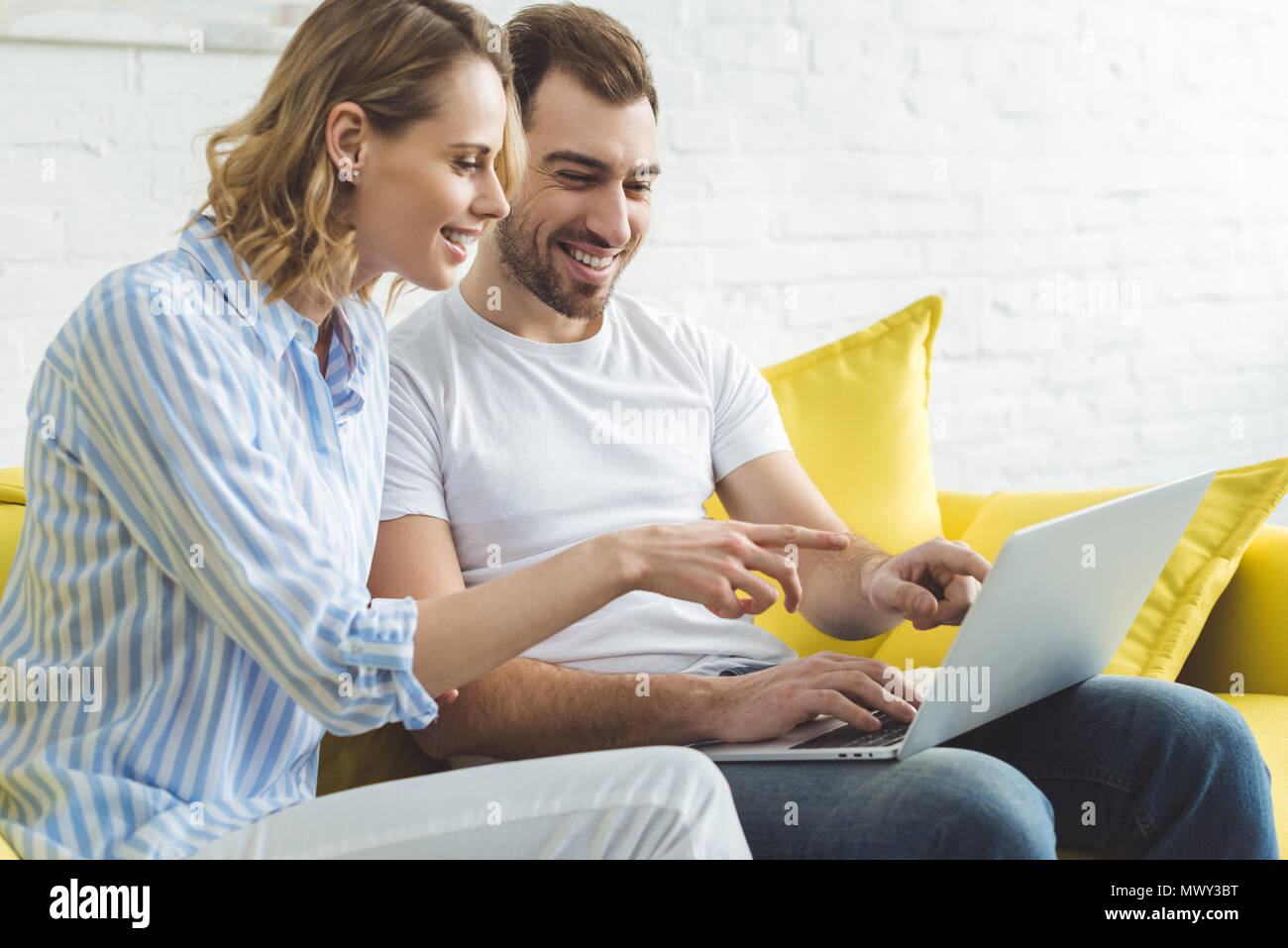 Young happy couple having fun with laptop Stock Photo - Alamy