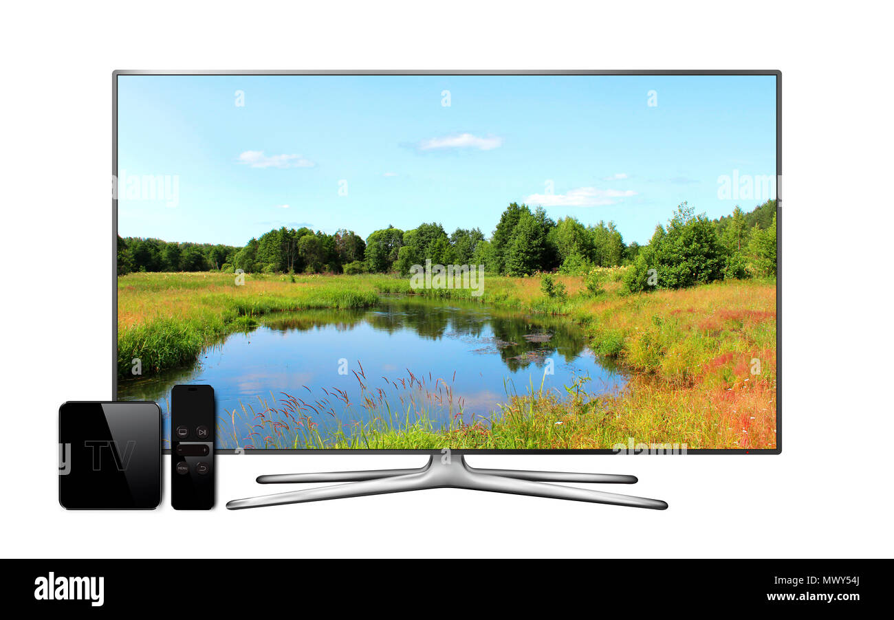 Smart tv and multimedia box with remote controller and landscape wallpaper on screen. Isolated on white background. Stock Photo