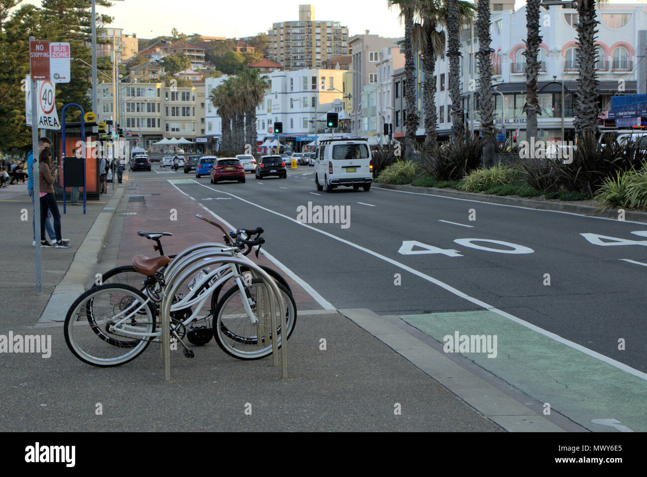 Street view of Sydney, Australia. Campbell Parade in Bondi suburb of Sydney. Moving cars and bicycles parked in rack on footpath. Stock Photo