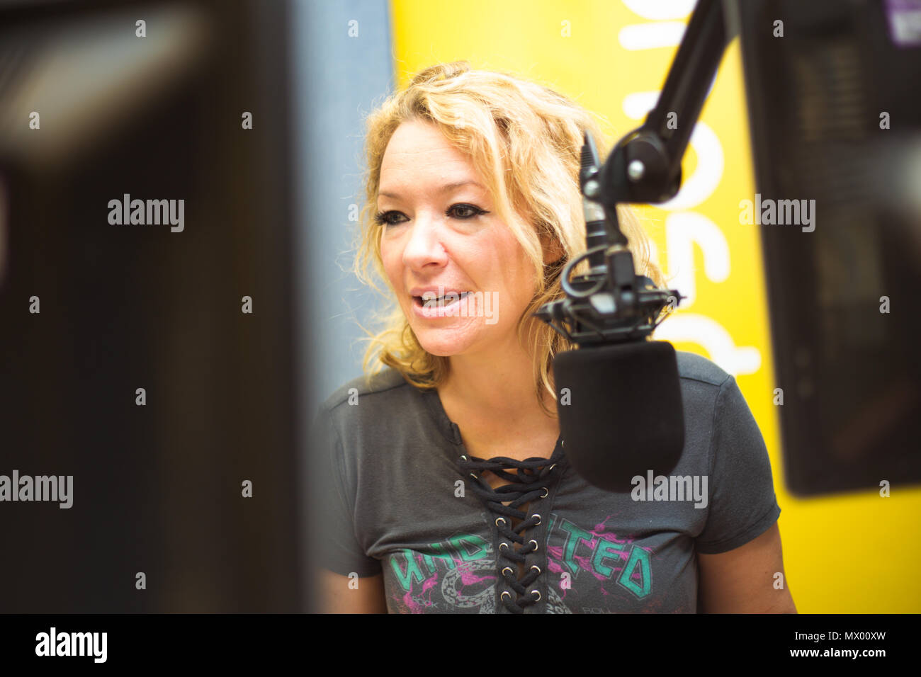 White British female DJ working inside recording studio with headphones