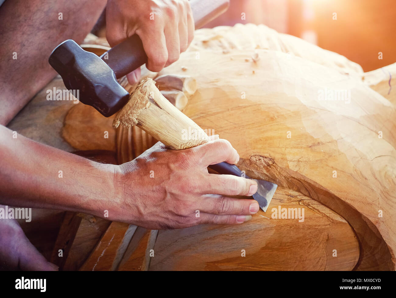 Closeup Old man Hands of craftsman wooden carve with a gouge in the hands on the workbench in carpentry Stock Photo