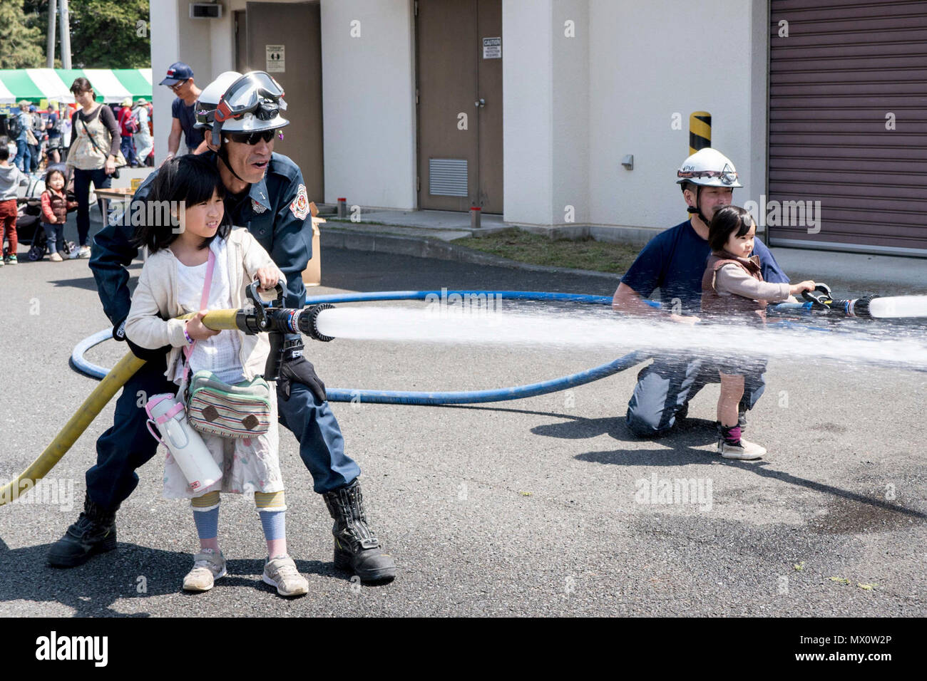 Naval Air Facility Atsugi Japan April 29 17 A Firefighter From Commander Navy Region Japan Fire Department Helps A Young Visitor Spray A Fire Hose At Naval Air Facility Naf Atsugi S Spring