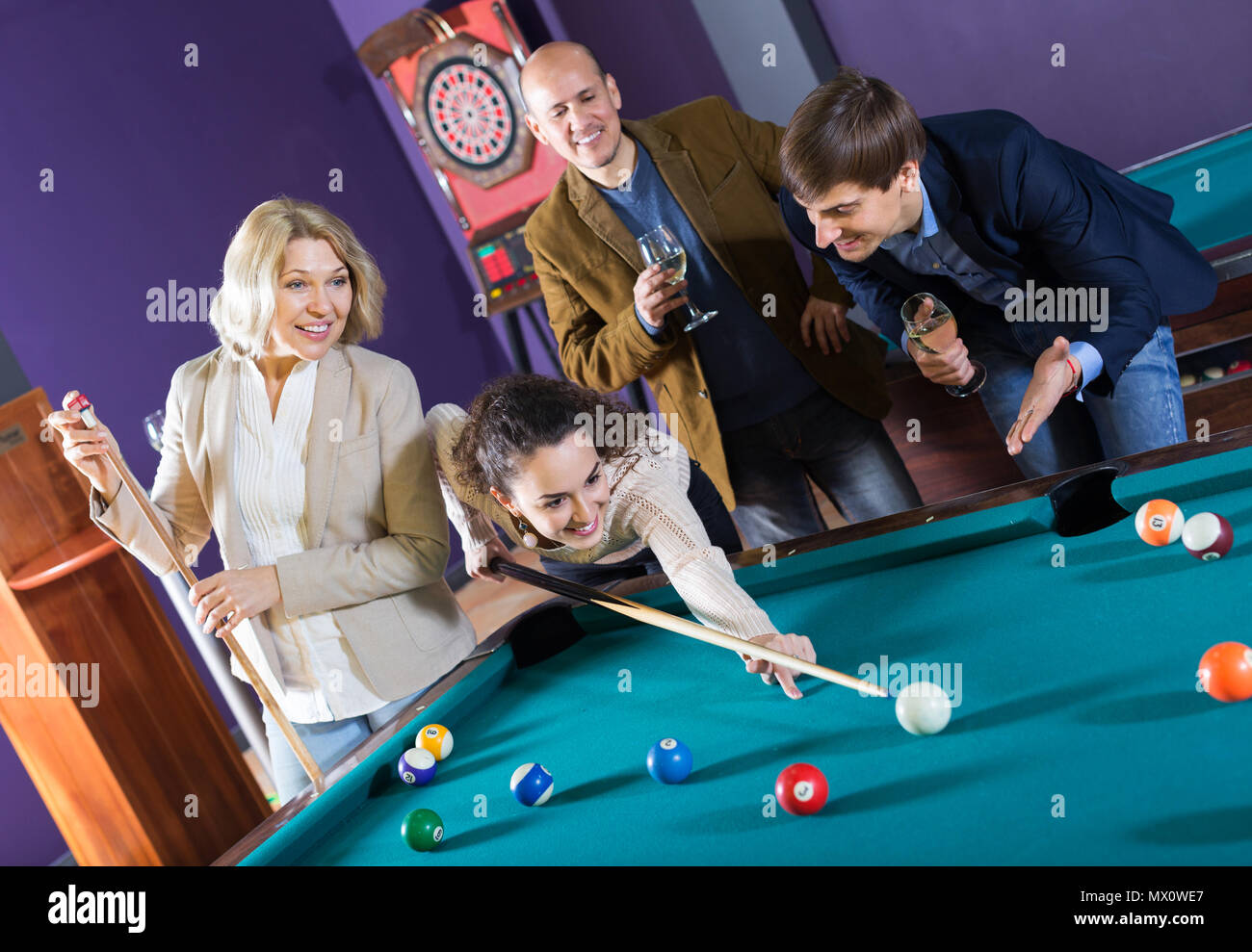 Relaxed happy people playing billiard and darts as hanging out Stock