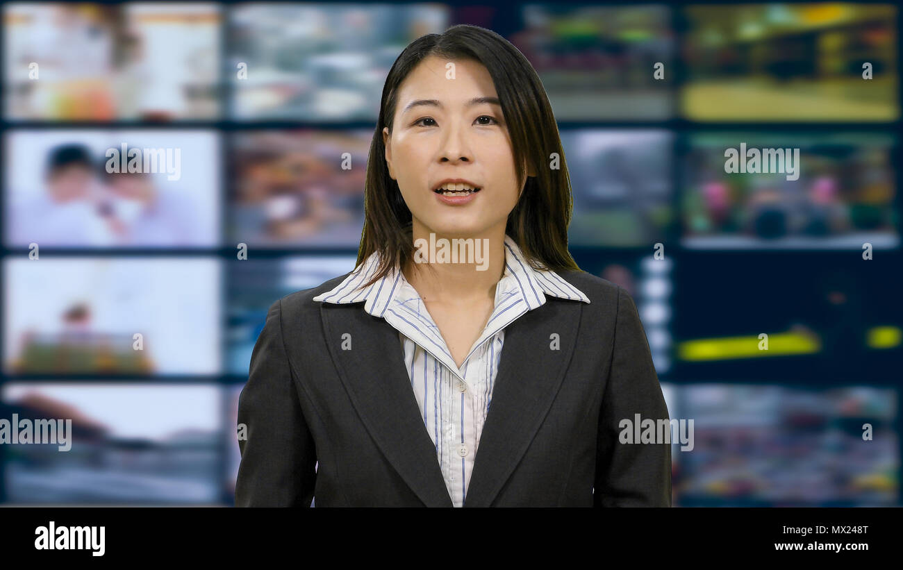 Asian American anchorwoman in TV studio Stock Photo