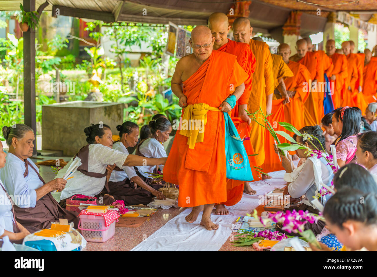 Kanchanaburi, Thailand - September 16, 2016: Buddhist Mon people celebrate the month of merit festival by offering flowers to monks in Sangkhlabri, Ka Stock Photo