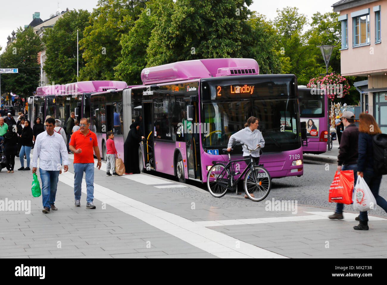 Orebro, Sweden - August 18, 2017: Violet colored public transportation city busses at stop Jarntorget in the city center. Stock Photo