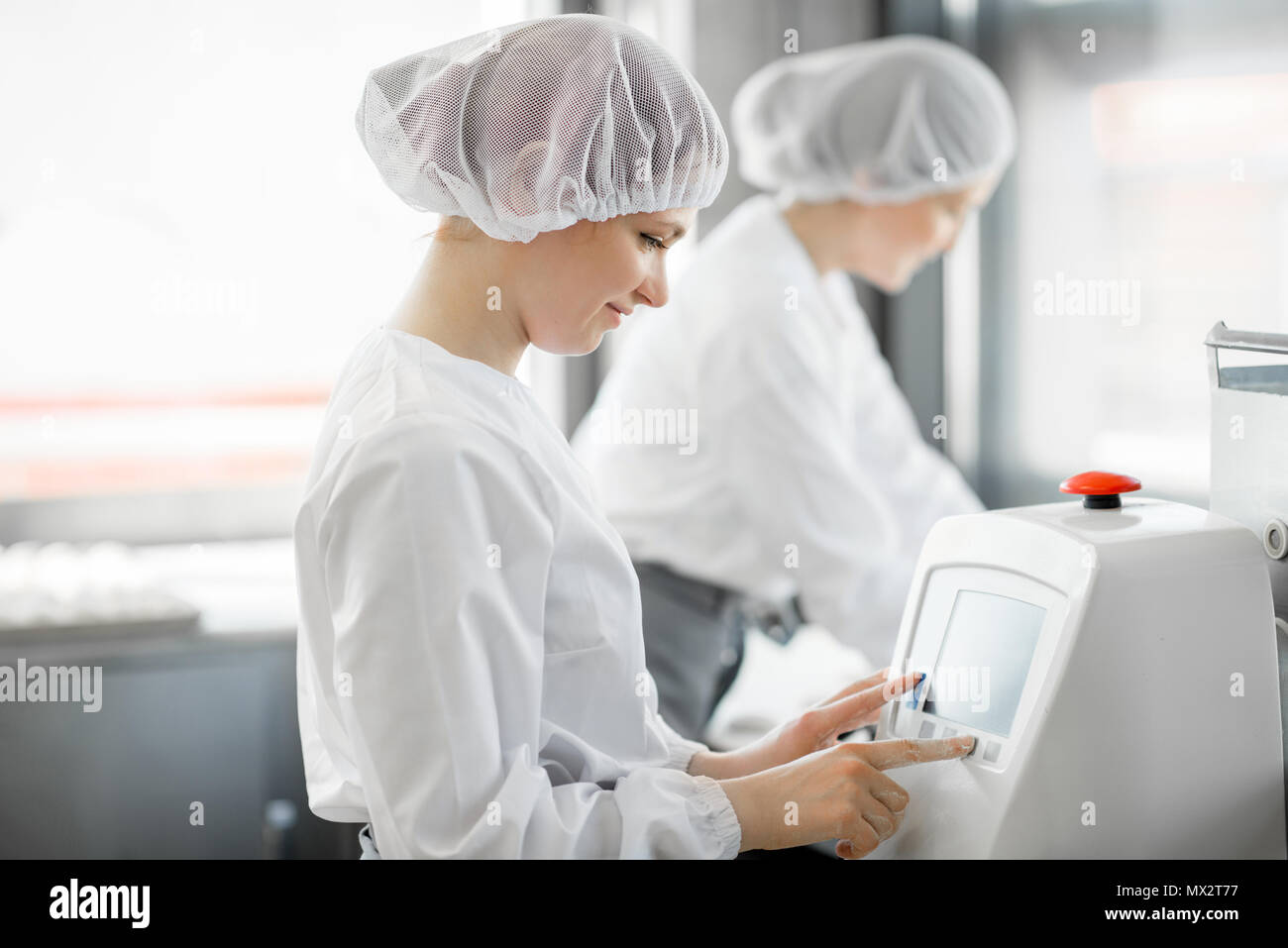 Women rolling dough at the manufacturing Stock Photo