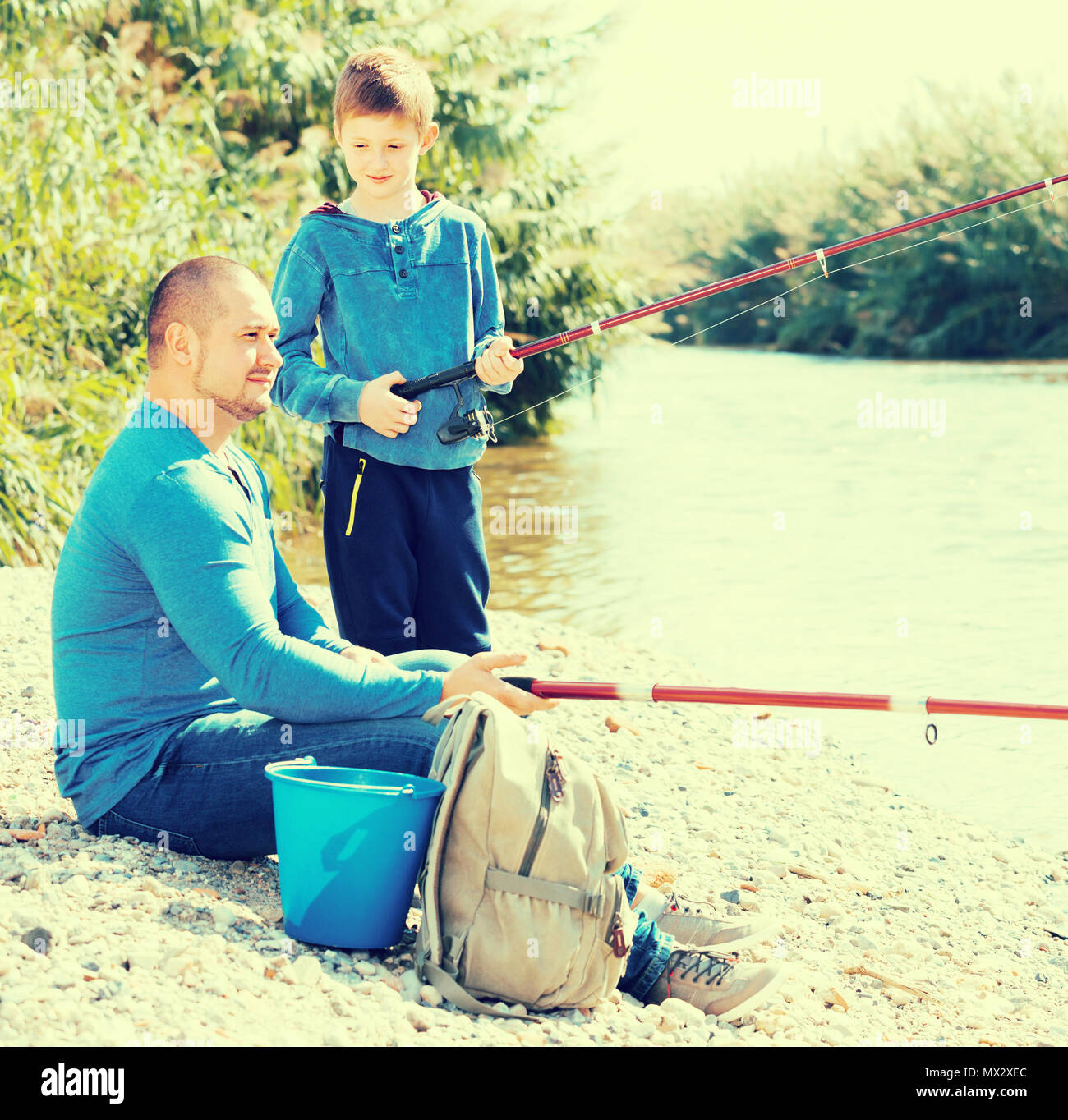 https://c8.alamy.com/comp/MX2XEC/young-father-and-son-fishing-with-rods-in-summer-day-MX2XEC.jpg