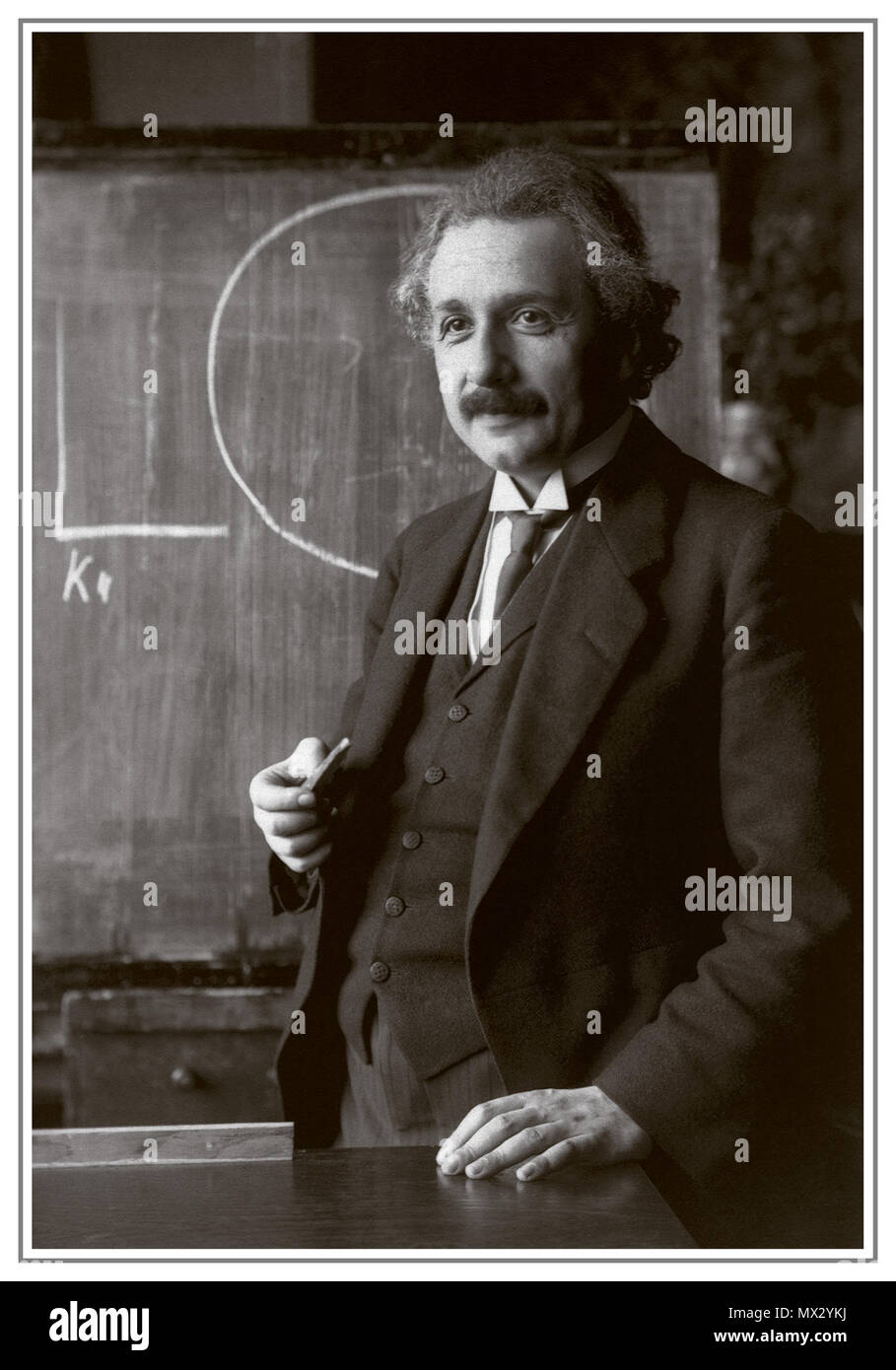 EINSTEIN LECTURE BLACKBOARD Vintage 1920's B&W image of Albert Einstein, winner of Nobel Prize for Physics in 1921 for his services to Theoretical Physics, and especially for his discovery of the law of the photoelectric effect'  shown during a lecture in Vienna in 1920's. Stock Photo