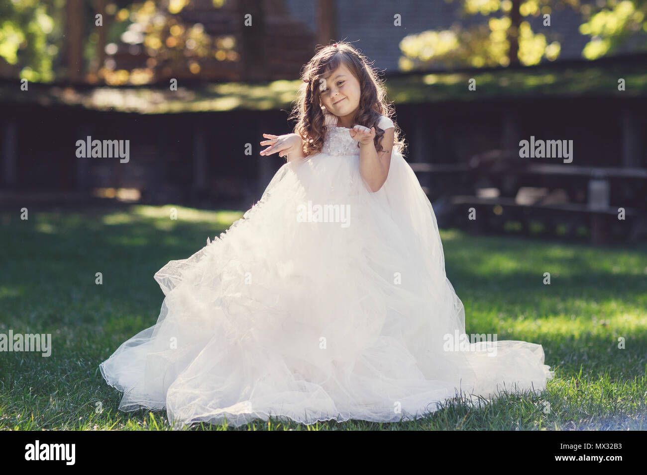 Outdoor portrait of adorable smiling little girl in white dress Stock Photo