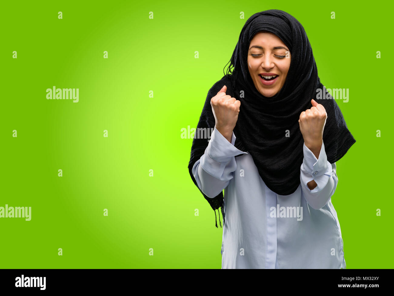 Young arab woman wearing hijab happy and excited celebrating victory ...