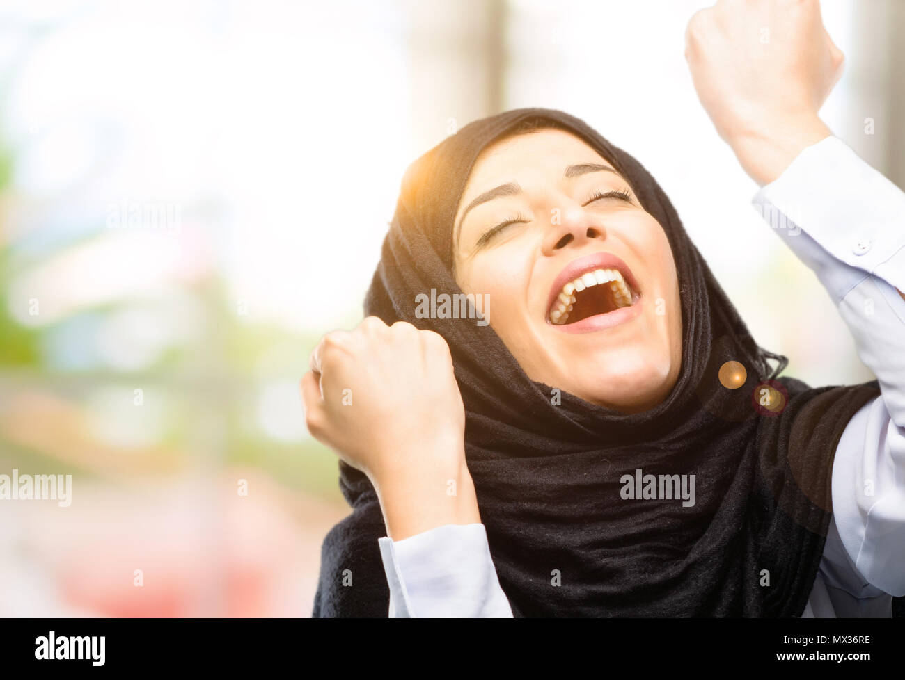 Young arab woman wearing hijab happy and excited celebrating victory ...