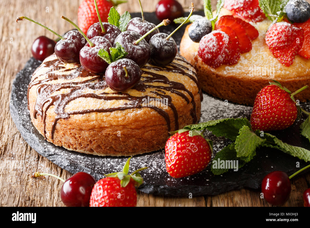 Dessert cakes with chocolate, mint, strawberries, cherries and blueberries close-up on the table. horizontal Stock Photo