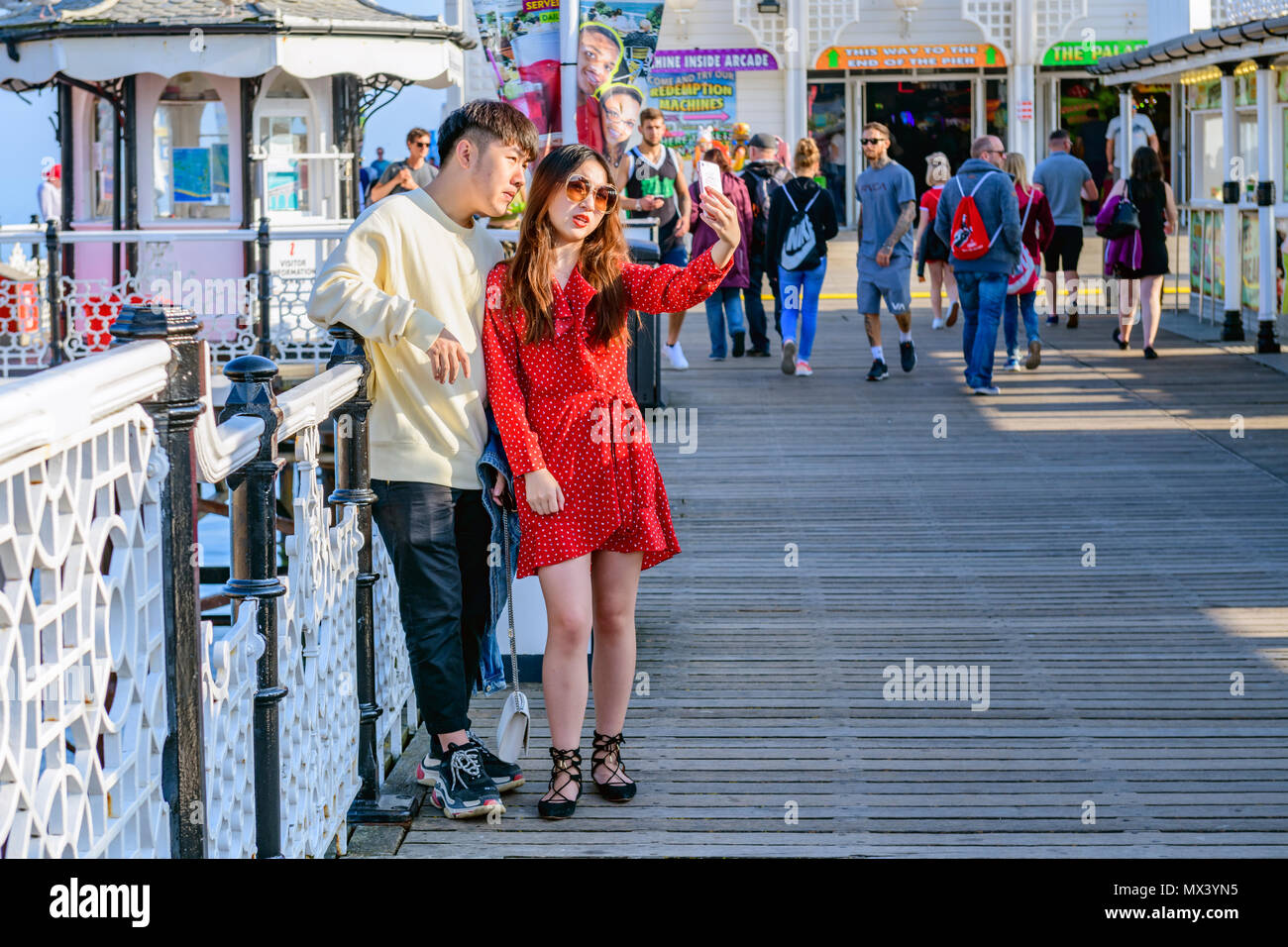an asian oriental couple posing for a selfie on brighton pier Stock Photo