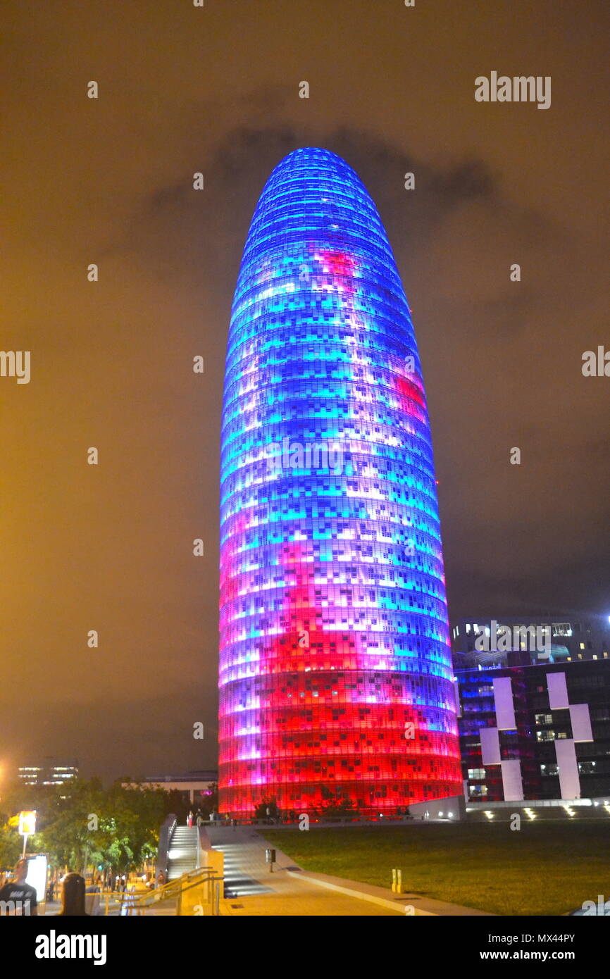 Vista Nocturna de la Torre Agbar uno de los iconos de Barcelona, iluminada con los colores típicos de Barcelona. Stock Photo