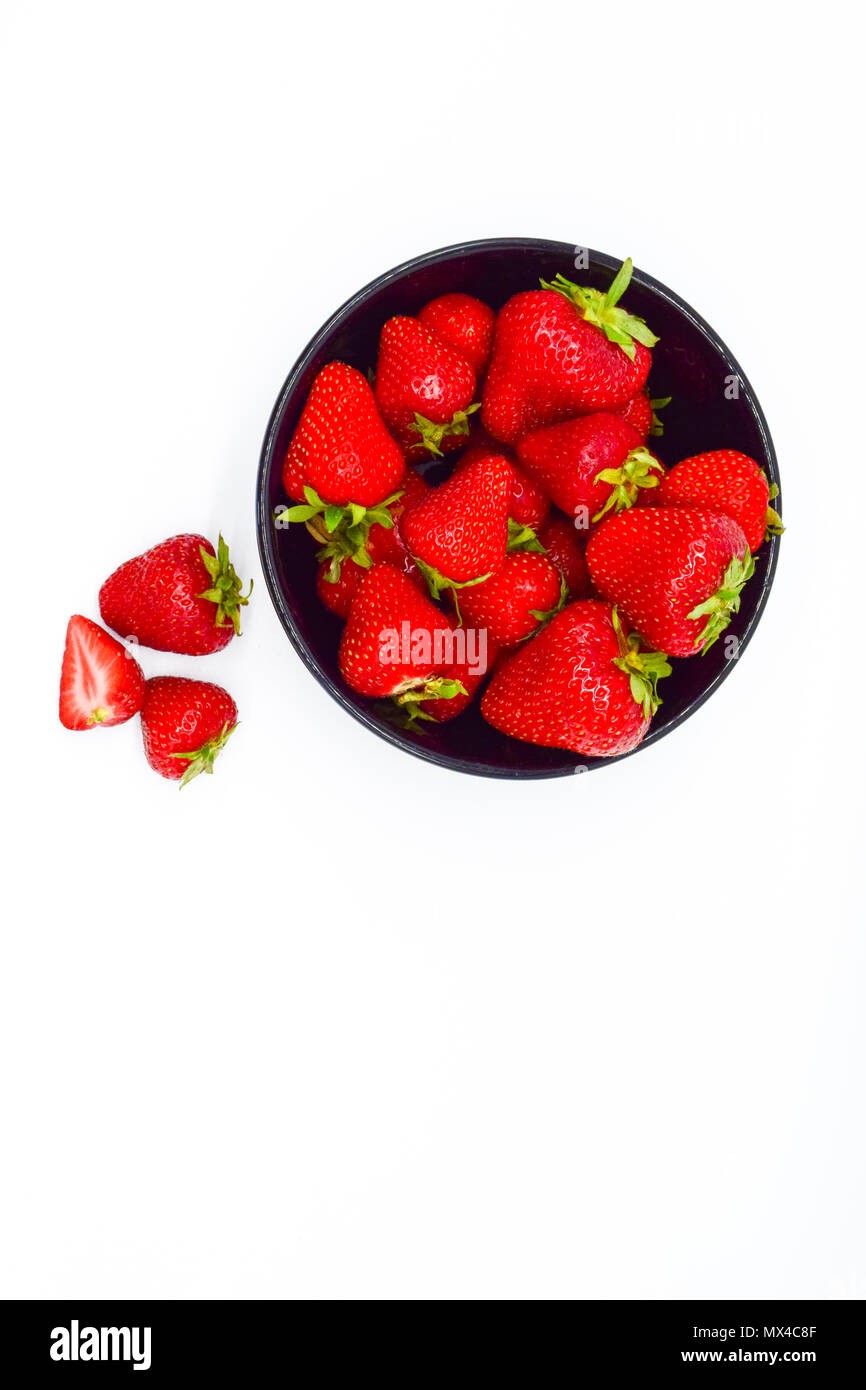 Black bowl of strawberries isolated on white background top view Stock ...