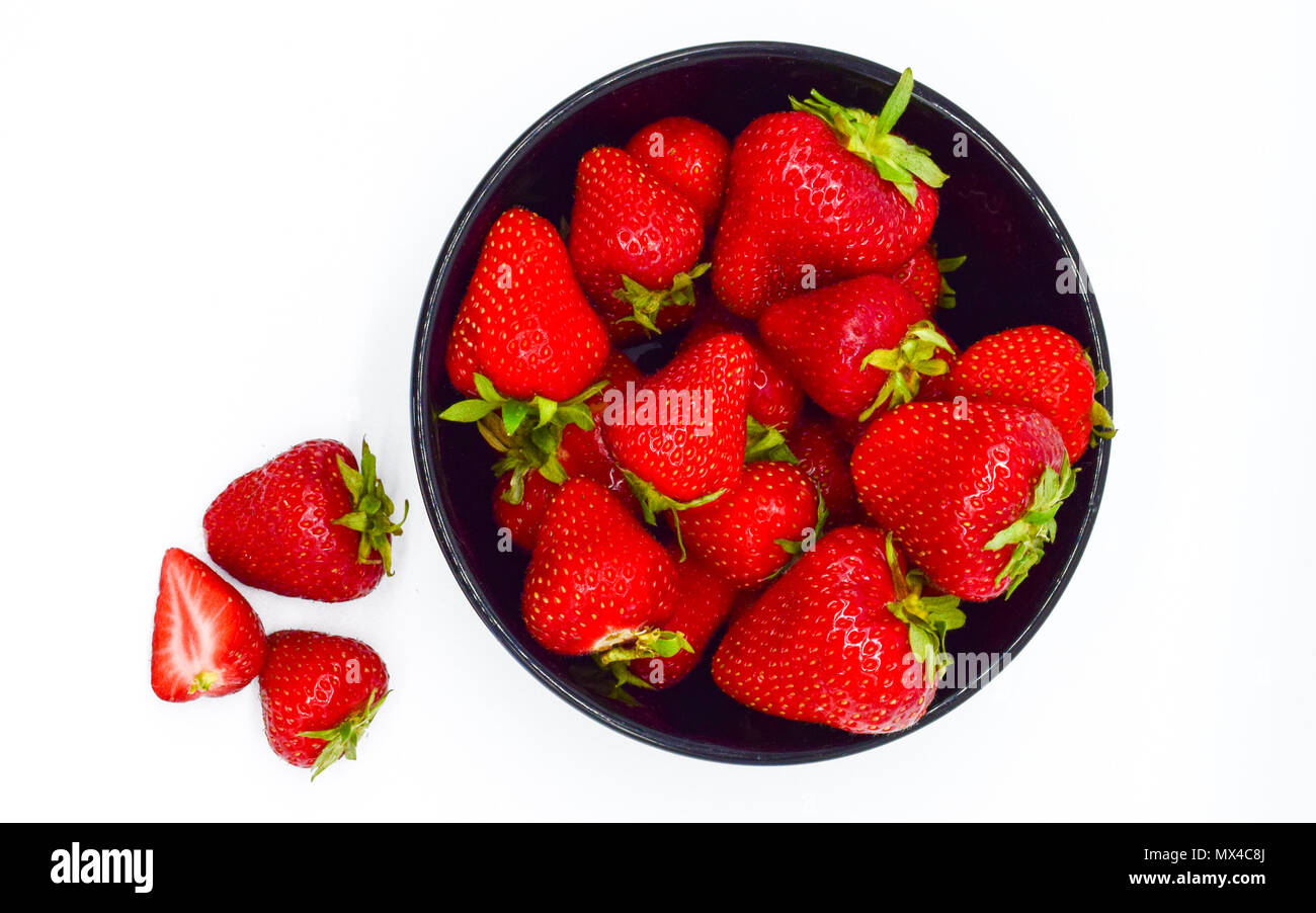 Black bowl of strawberries isolated on white background top view Stock ...