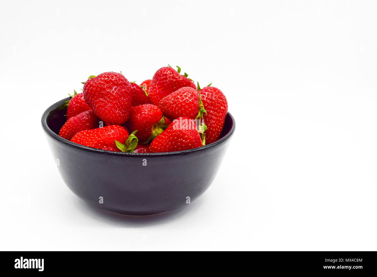 Black bowl of strawberries isolated on white background Stock Photo - Alamy