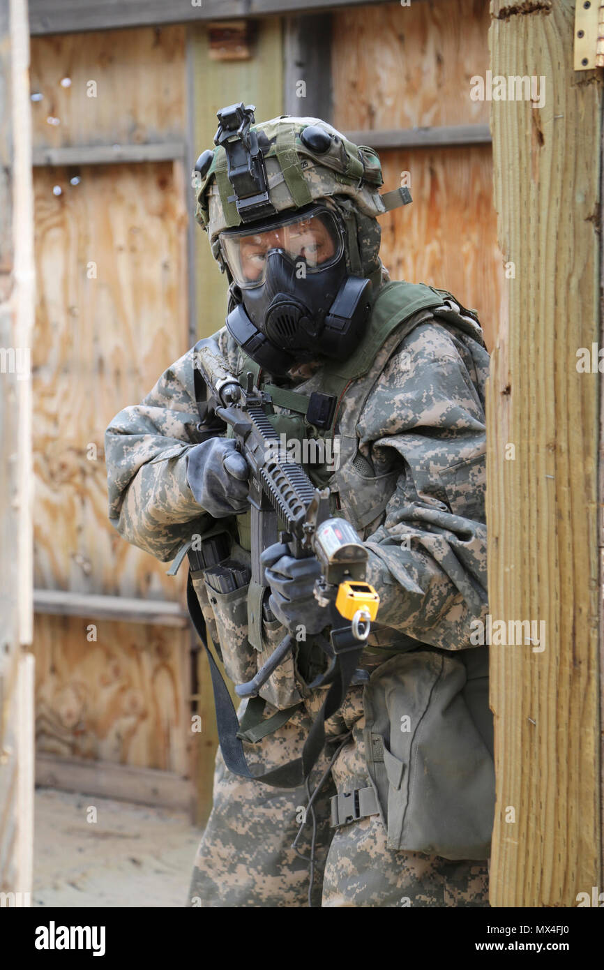 U.S. Army Sgt. Ramona Clements, 717th Ordnance Company (EOD), 184th Ordnance Disposal Battalion (EOD), 52nd Ordnance Group (EOD), clears an entryway during a mass casualty situational training exercise (STX) lane at the Yakima Training Center, Yakima, Wash., April 28, 2017. The final days of the CBRNE Leaders Course are comprised of STX lanes that test what the Soldiers' learned throughout the duration of the course. Stock Photo