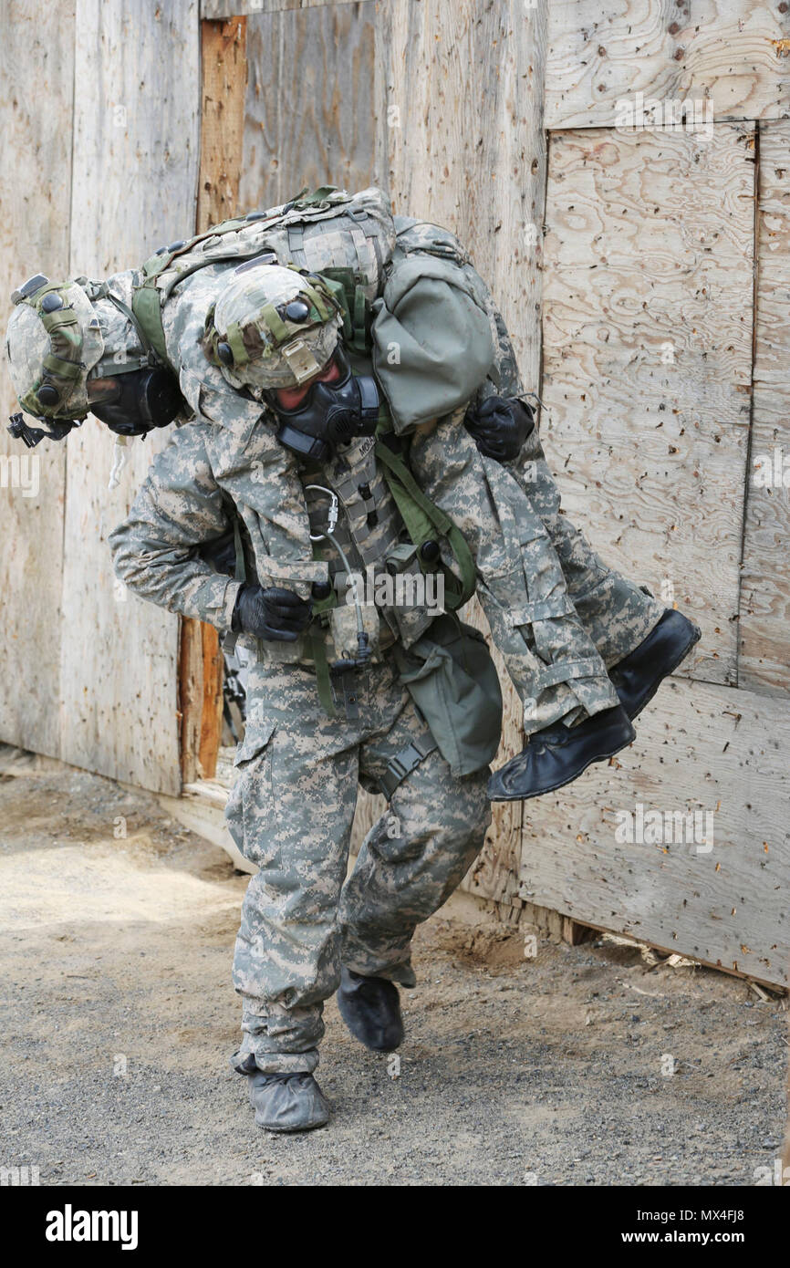 U.S. Army Sgt. Carlos Moran, 744th Ordnance Company (EOD), 184th Ordnance Disposal Battalion (EOD), 52nd Ordnance Group (EOD), carries a simulated casualty to a casualty collection point during a mass casualty situational training exercise (STX) lane at the Yakima Training Center, Yakima, Wash., April 28, 2017. The final days of the CBRNE Leaders Course are comprised of STX lanes that test what the Soldiers' learned throughout the duration of the course. Stock Photo