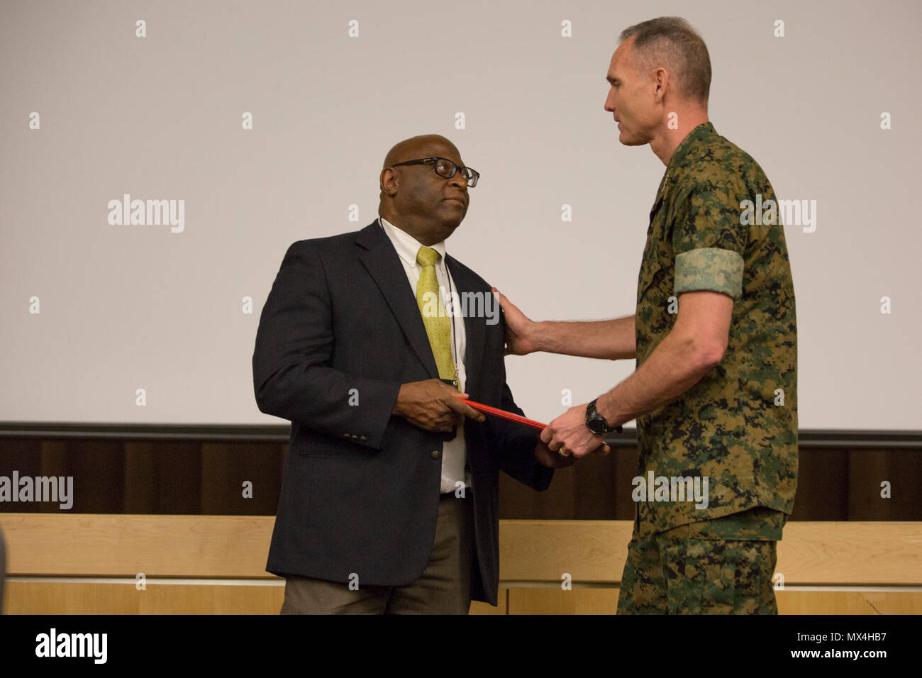 U.S. Marine Corps Lt. Gen. Gary L. Thomas, deputy commandant, Programs and  Resources, Headquarters Marine Corps (HQMC), awards Mr. Maxwell Stringer,  accountant, Risk and Compliance Branch, HQMC, a career federal length of