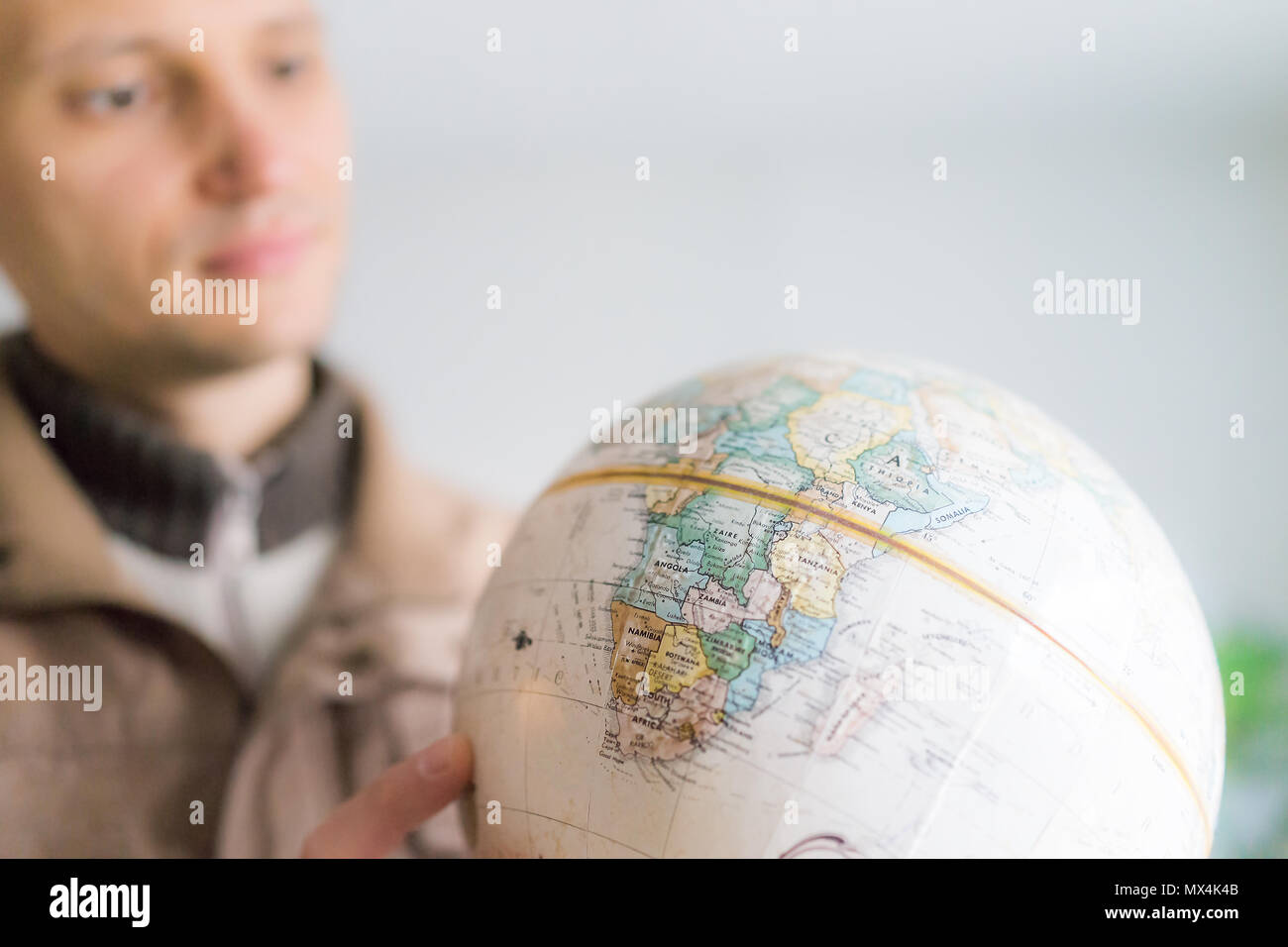 Young Man Holding Looking At Vintage Retro Old Brown Globe World Map With Equator Africa Continent Stock Photo Alamy