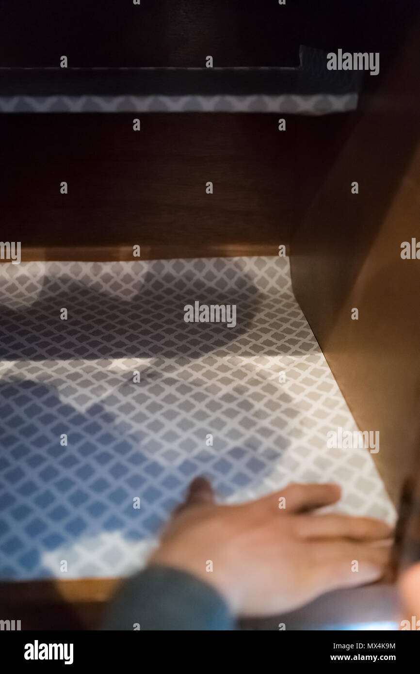 Man hands placing protective adhesive liner sheet inside on wooden