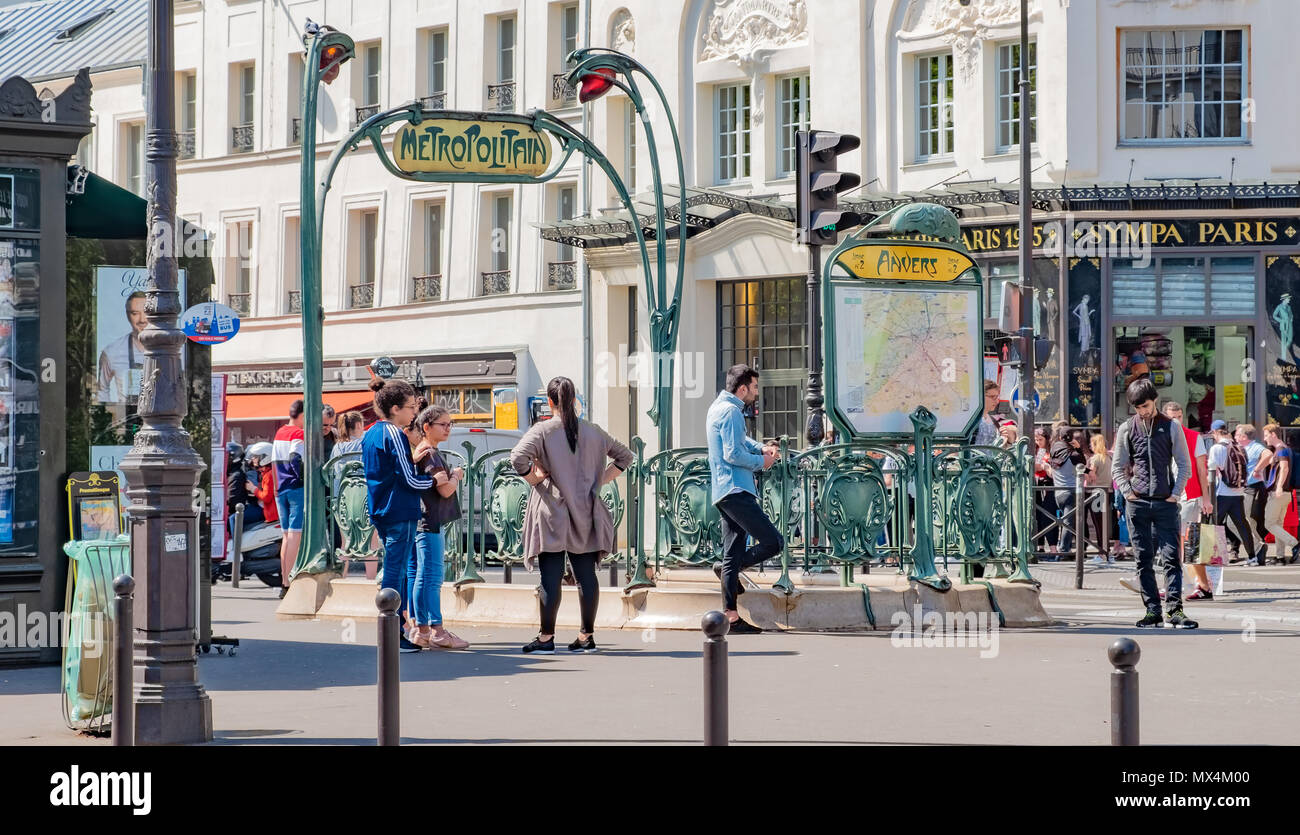 People lingering around the Hector Guimard designed entrance to the Anvers Metropolitain Station in Paris. Stock Photo