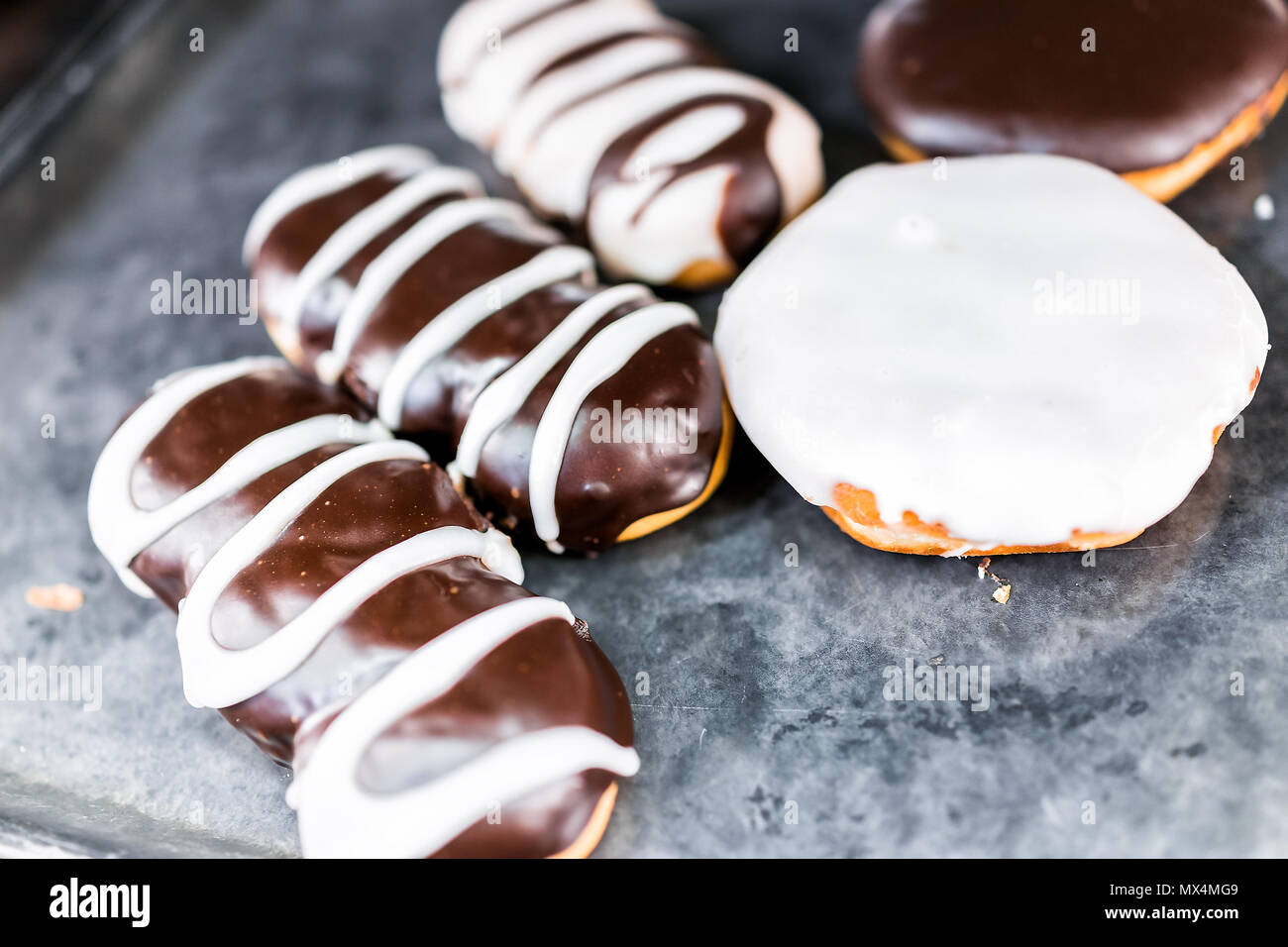 Chocolate brown and white icing long john eclair donuts closeup on