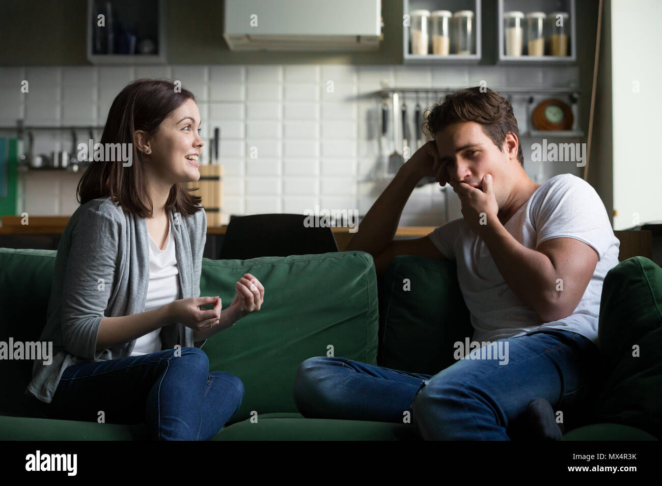 Young husband yawning getting bored listening to excited wife ta Stock Photo
