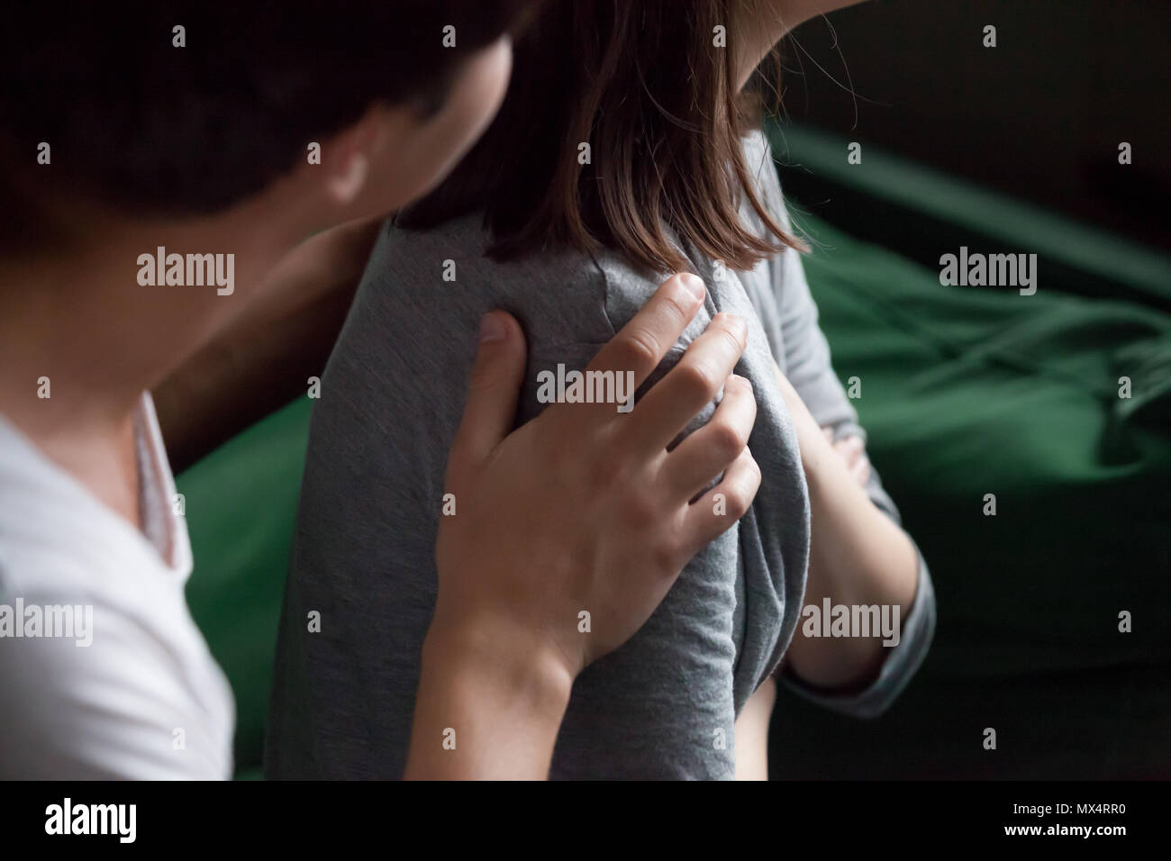 Helping male hand holding female shoulder closeup, psychological Stock Photo