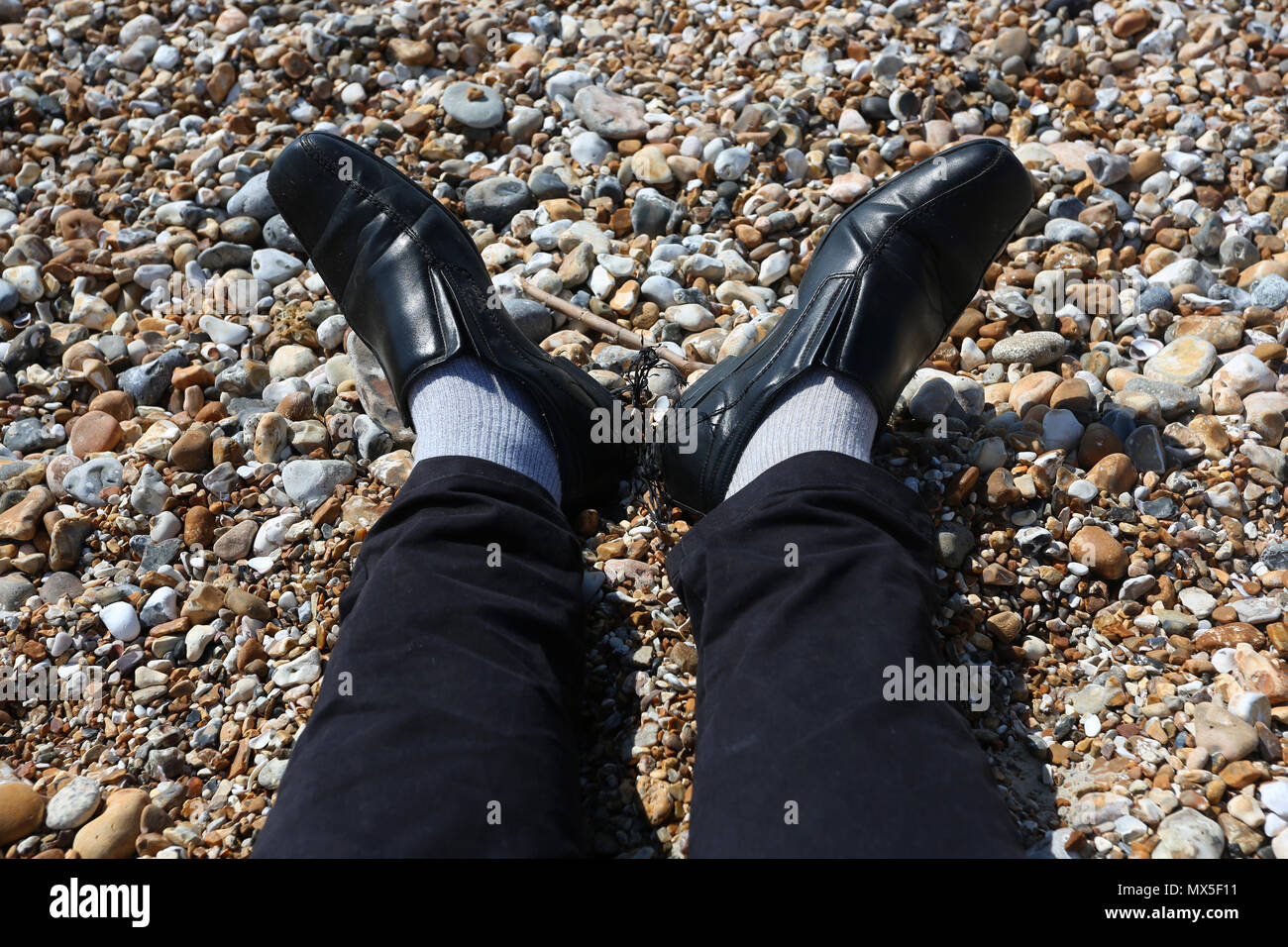 An office worker relaxing on the beach in UK. Stock Photo