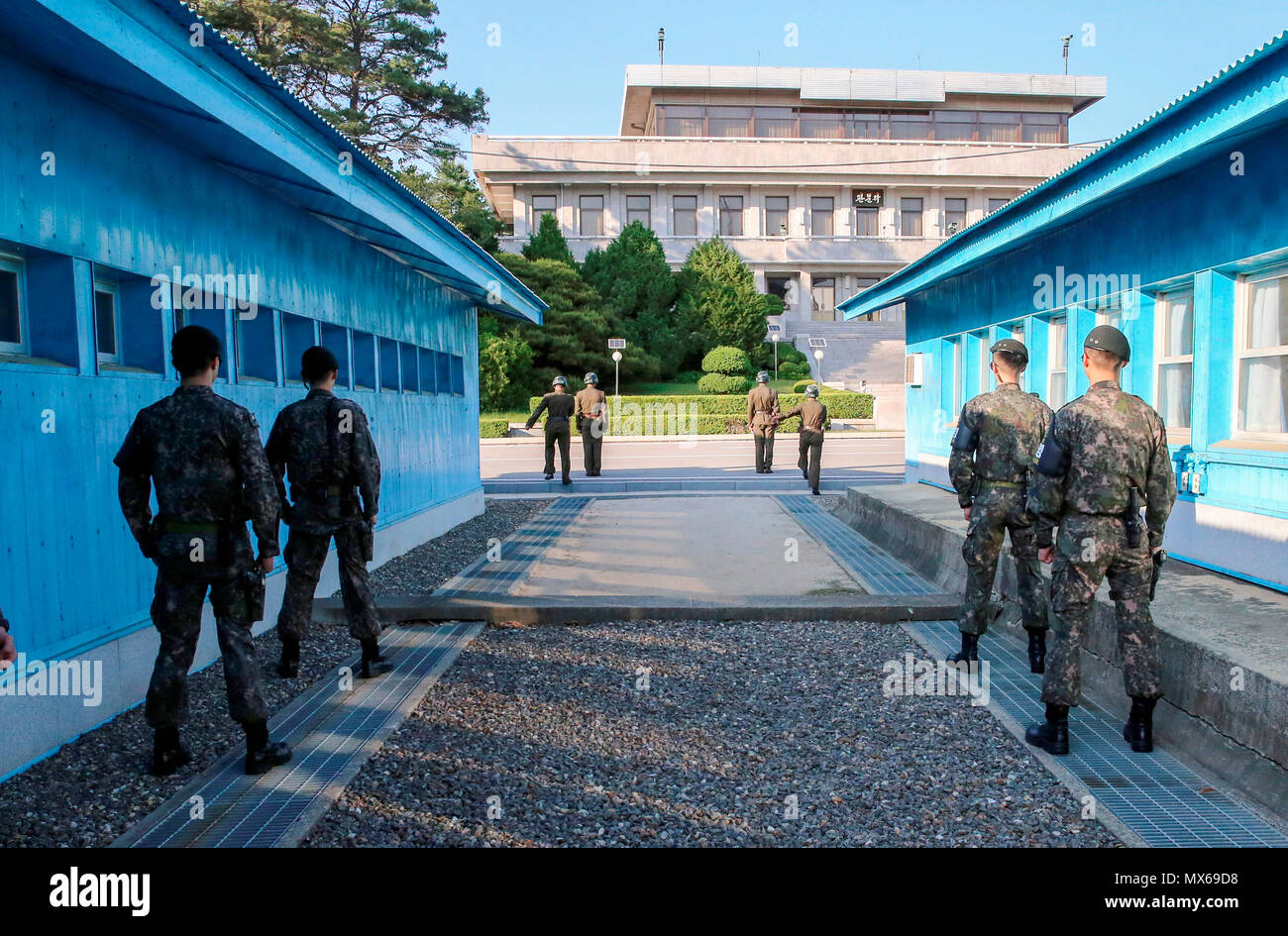 Panmunjom, June 1, 2018 : South Korean soldiers (front) and North Korean soldiers stand guard after inter-Korean high-level talks at the border truce village of Panmunjom, north of Seoul, South Korea. The high-level talks was held on Friday to discuss steps to implement agreements reached during the April 27 inter-Korean summit. South and North Koreas agreed on June 1 to hold general-level military talks on June 14 at the Panmunjom as part of efforts to ease tensions between the two Koreas and agreed to hold a Red Cross meeting on June 22 at North Korea's Mount Kumgang resort to discuss holdin Stock Photo