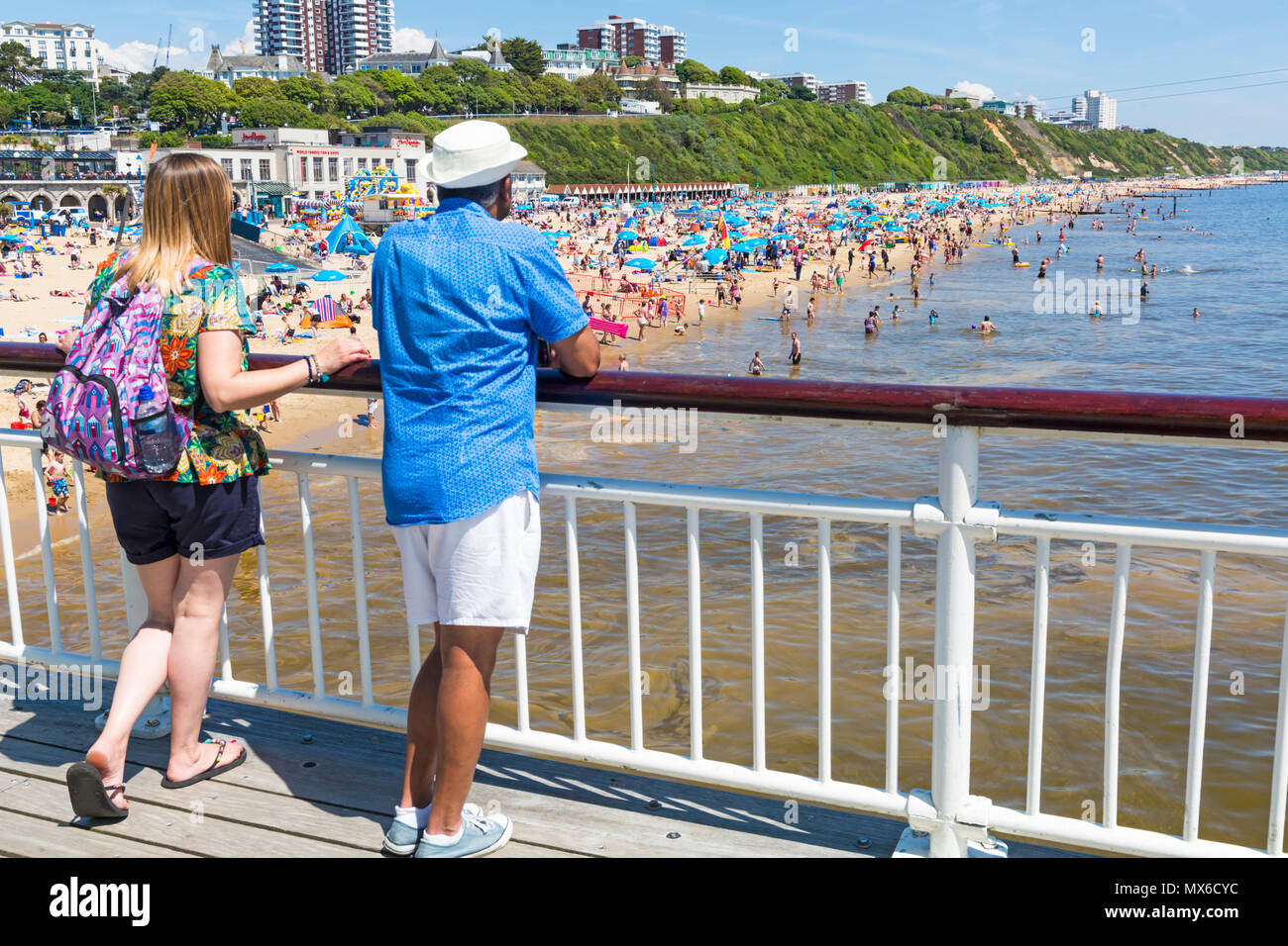 Bournemouth, Dorset, UK. 3rd June 2018. UK weather: beaches are busy on a lovely warm sunny day with unbroken sunshine, as visitors head to the seaside to make the most of the sun and sea and top up their tans. Couple standing on Bournemouth Pier looking at the crowded beach. Credit: Carolyn Jenkins/Alamy Live News Stock Photo