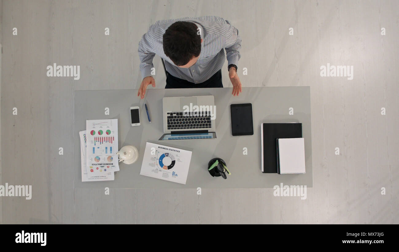 Businessman Videoconferencing On Computers At Desk Top View