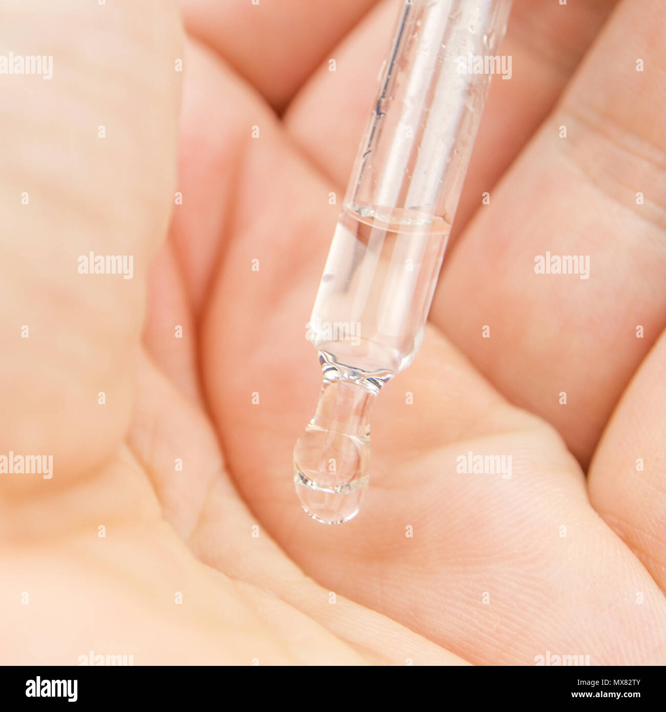 last drop of water hanging out of an empty transparent glassy pipette