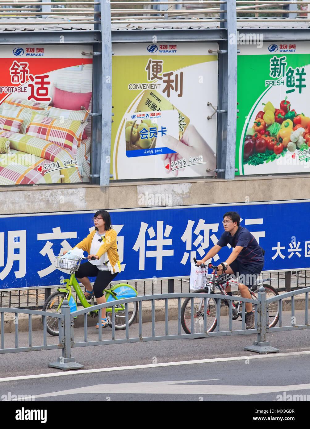 BEIJING-JULY 27, 2015. Large billboards near cycle lane in city center. Outdoor advertising became China’s third largest medium after TV and print. Stock Photo