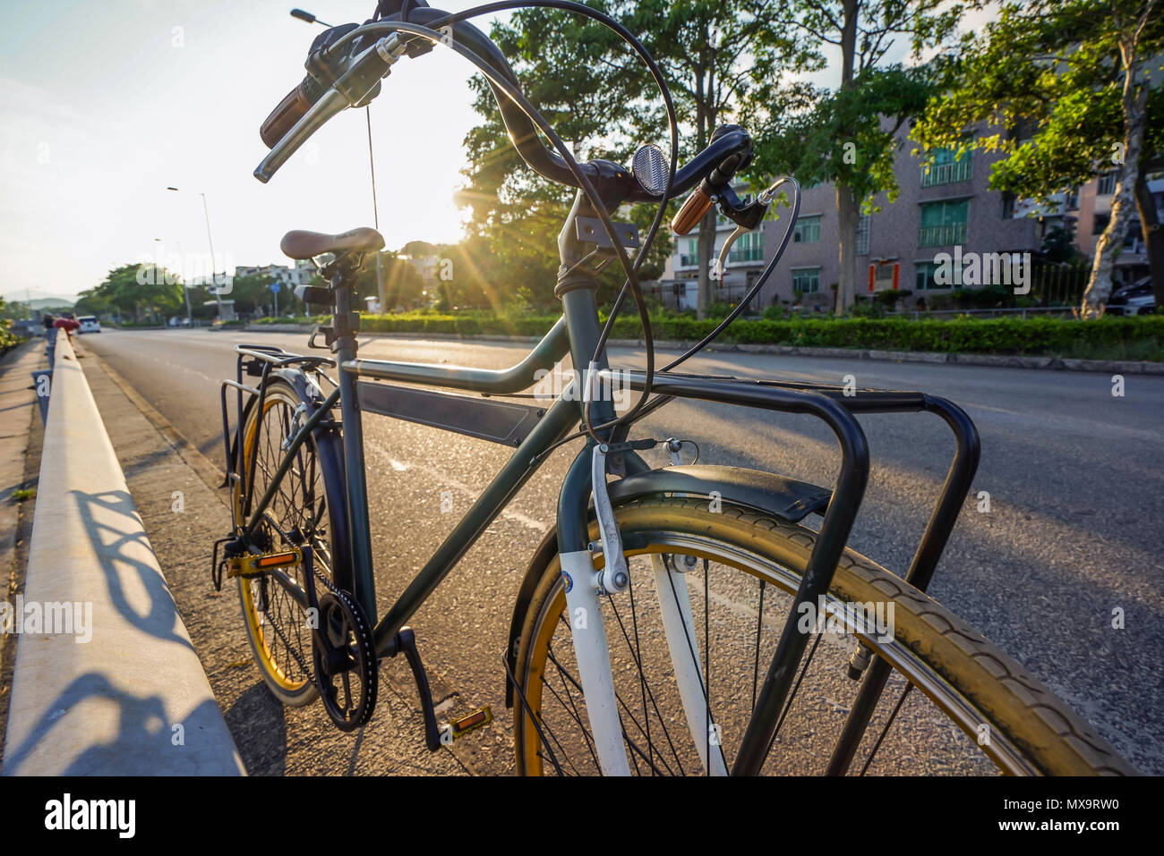 The green retro bicycle with brown leather seat and flare light from sun Stock Photo Alamy