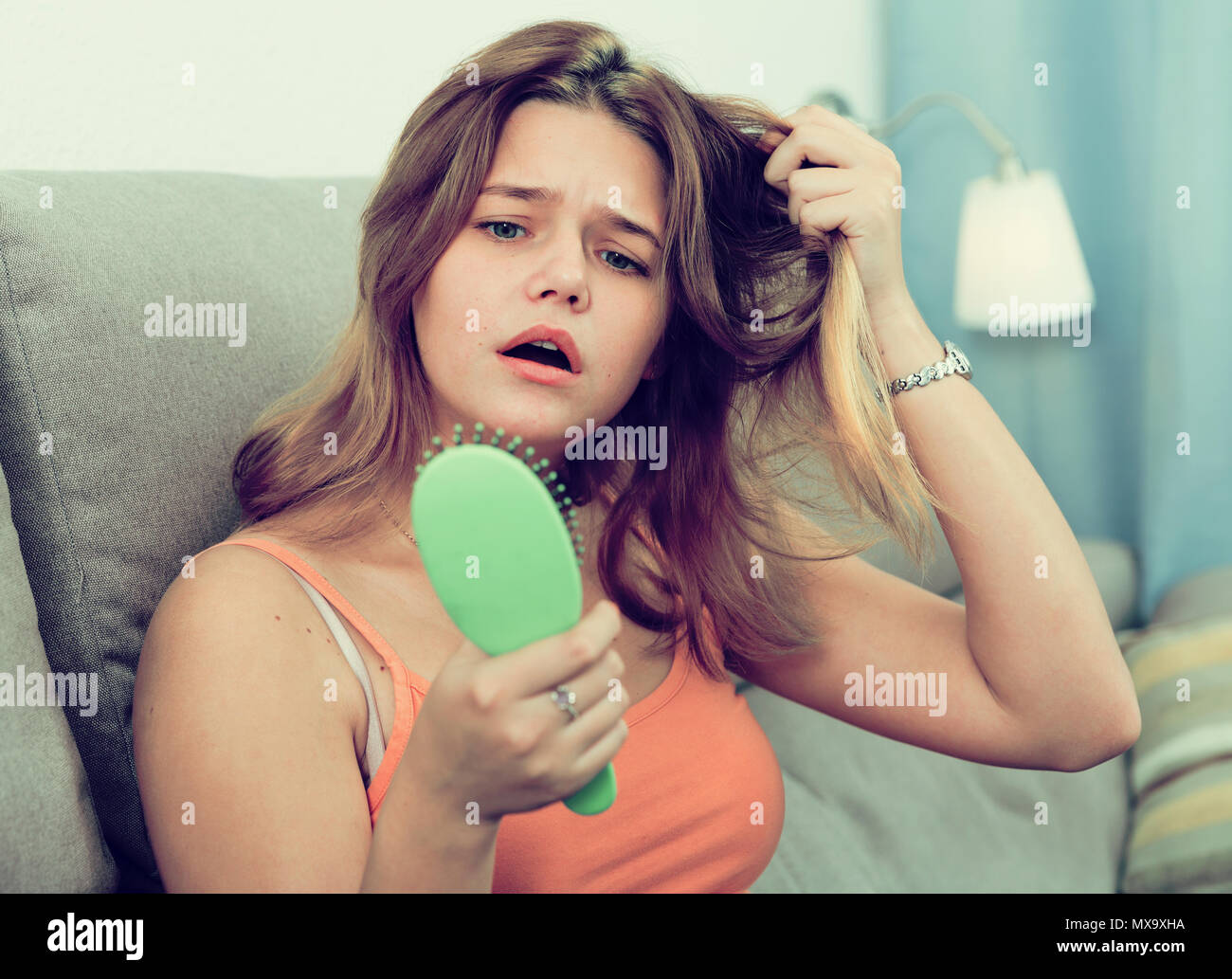 Girl in a panic because her hair falls out at home Stock Photo Alamy