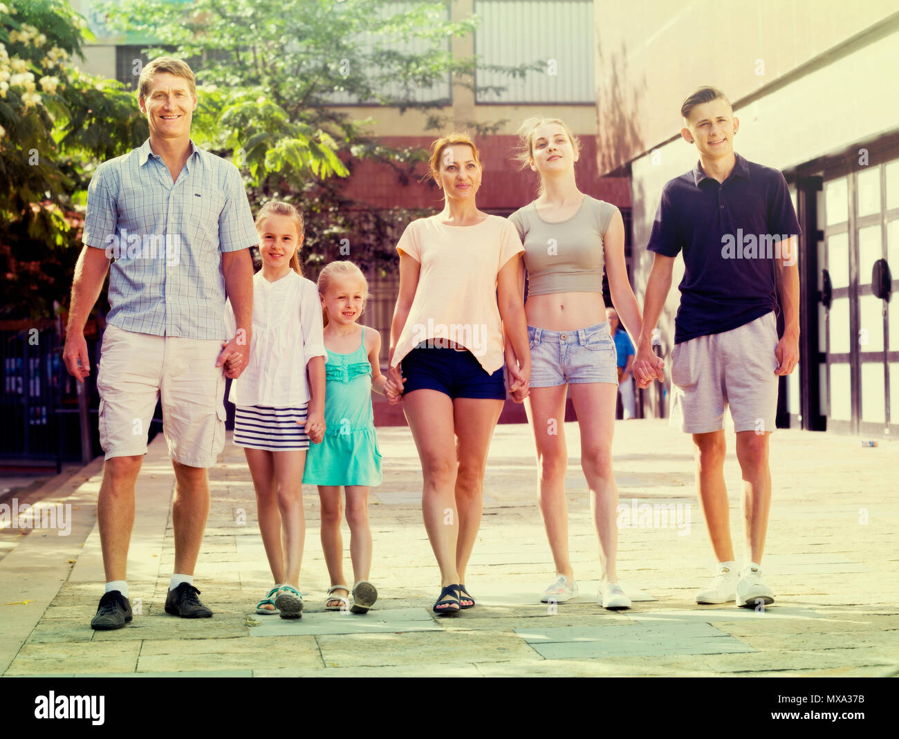 family of six people happily walking together in summer city Stock ...