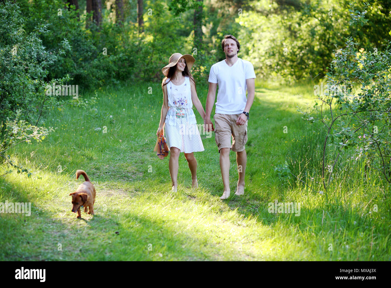 Young couple walking in the woods in the summer Stock Photo - Alamy